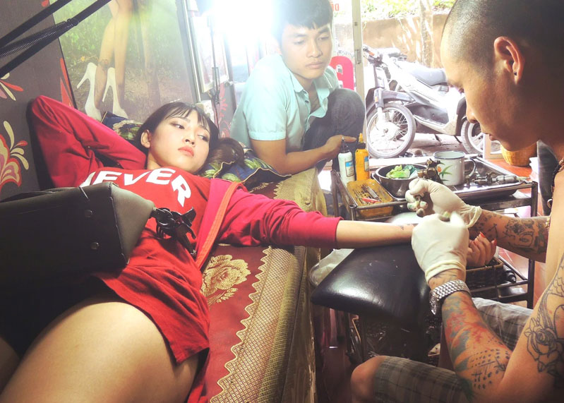 Thợ xăm tại Đạt Tattoo thực hiện xăm hình cho khách hàng trong không gian chuyên nghiệp.