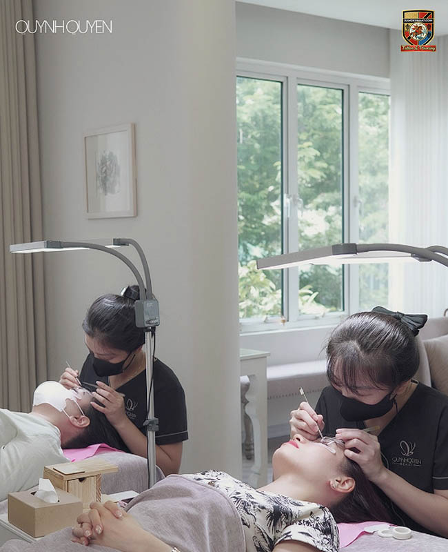 Kỹ thuật viên đeo khẩu trang đang tỉ mỉ thực hiện dịch vụ nối mi cho khách hàng tại địa chỉ điêu khắc chân mày và thẩm mỹ uy tín.