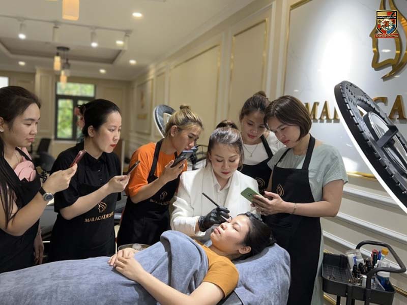 Giảng viên đang thị phạm kỹ thuật điêu khắc chân mày cho học viên tại địa chỉ học điêu khắc chân mày uy tín.