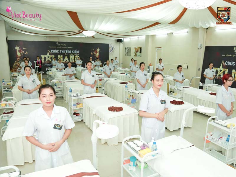 Các thí sinh mặc đồng phục y tế đứng trang nghiêm bên giường thực hành tại Cuộc thi tìm kiếm tài năng VietBeauty Academy.