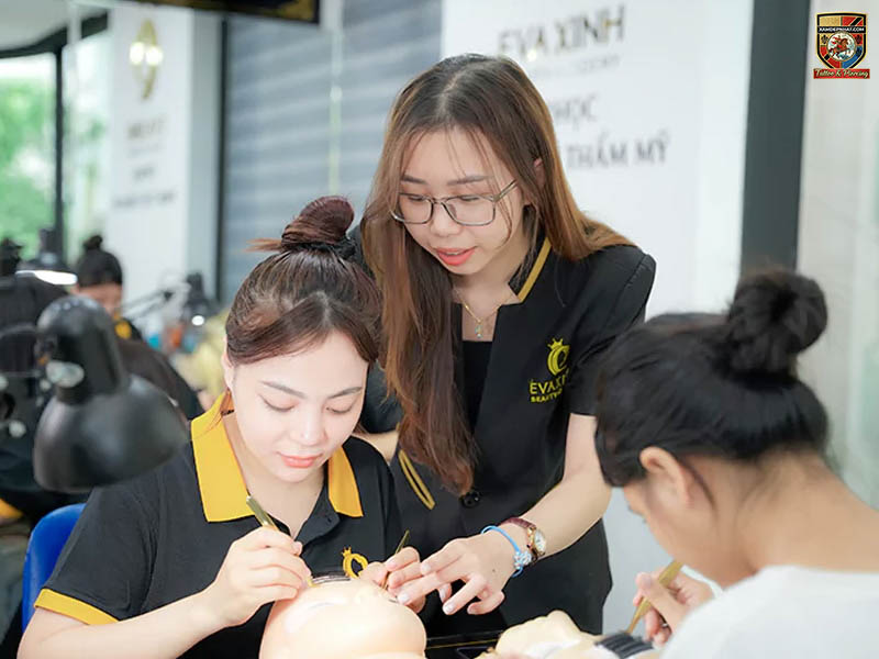 Giảng viên Eva Xinh đang trực tiếp hướng dẫn học viên thực hành kỹ thuật nối mi trên ma-nơ-canh