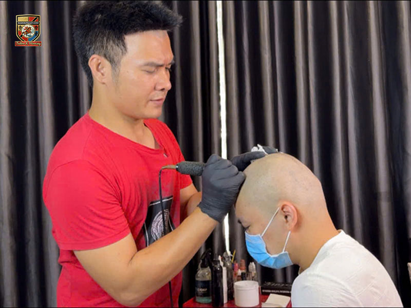 Master Tran Manh Thang performing hands-on SMP hairline dotwork during the best scalp micropigmentation training Hanoi program