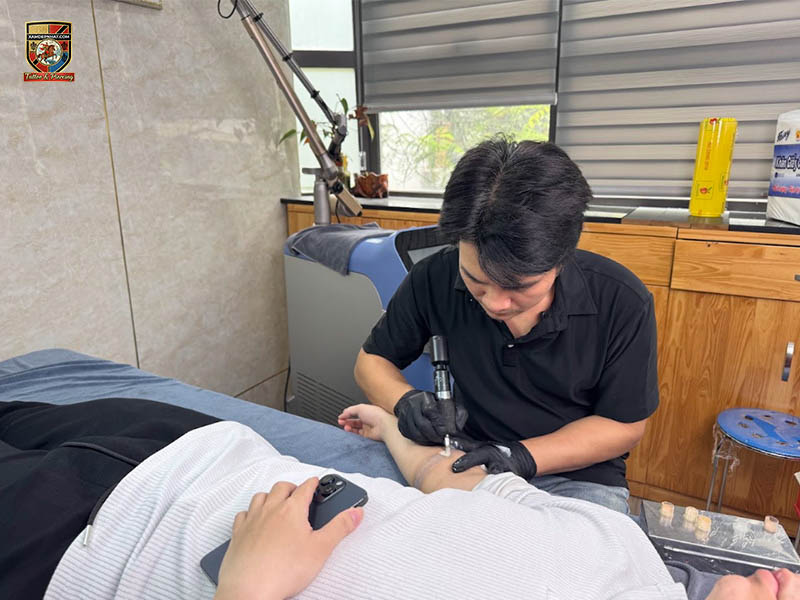 Instructor practicing skin pigment matching during scar camouflage tattoo training near me in Hanoi.
